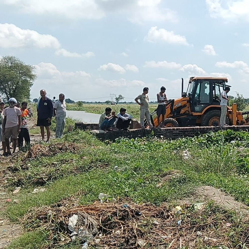 एटा में बंबे की पुलिया चोक होने से बढ़ा जलस्तर:बुलडोजर से सफाई कराकर टला जलभराव का खतरा, जलकुंभी हटने के बाद शुरू हुई निकासी