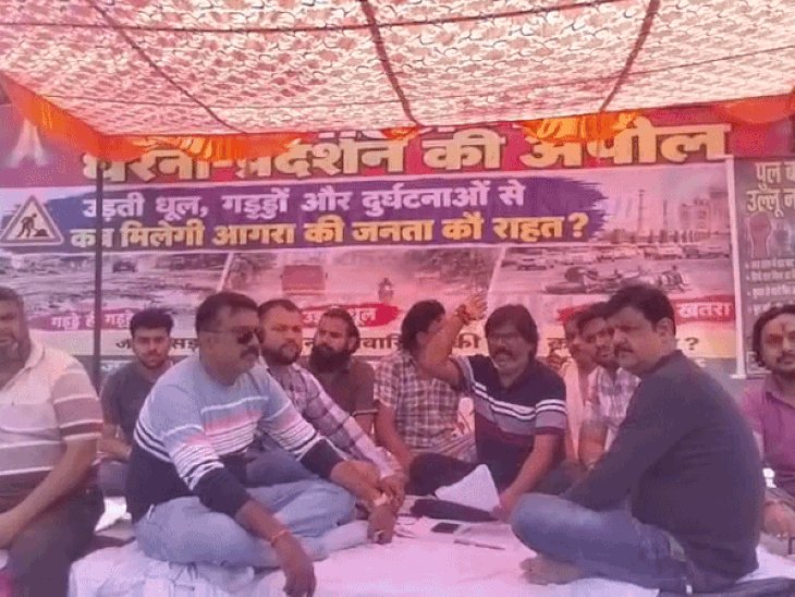 आगरा में ईदगाह-खेरिया ROB बंद,धरने पर बैठे व्यापारी:लोगों ने लगाए पुल बनाओ उल्लू न बनाओ के पोस्टर, बोले- 8 साल में 4 बार उद्घाटन, बने सिर्फ 4 पिलर