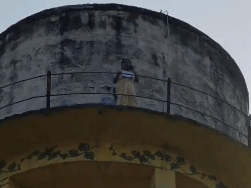 हाईकोर्ट के पास पानी की टंकी पर चढ़ी महिला:100 फीट की ऊंचाई से पत्र फेंके, लिखा- मंदिर को बचा लीजिए; पुलिस समझा रही